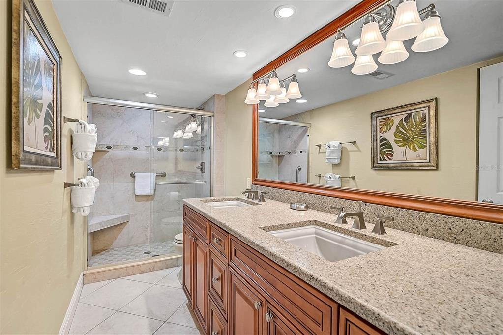 6518 Midnight Pass Road, Unit 407 Sarasota, FL 34242 - Photo 21 of 48 a bathroom with a granite countertop sink a large mirror and shower