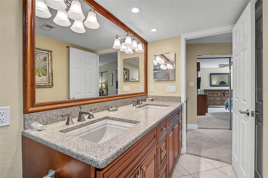 6518 Midnight Pass Road, Unit 407 Sarasota, FL 34242 - Photo 22 of 48 a bathroom with a granite countertop sink and a mirror