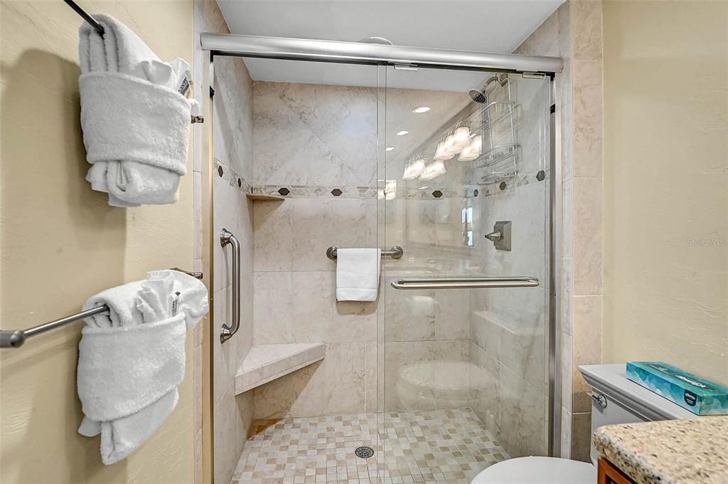 6518 Midnight Pass Road, Unit 407 Sarasota, FL 34242 - Photo 23 of 48 a bathroom with a glass shower door
