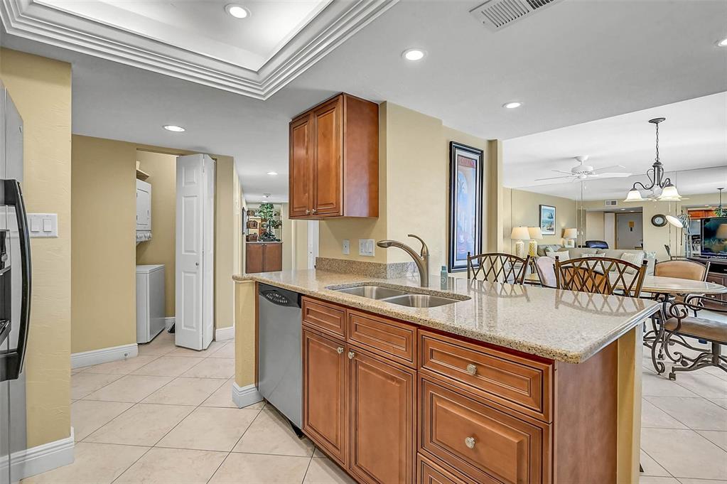 6518 Midnight Pass Road, Unit 407 Sarasota, FL 34242 - Photo 24 of 48 a kitchen with stainless steel appliances granite countertop a sink and a refrigerator