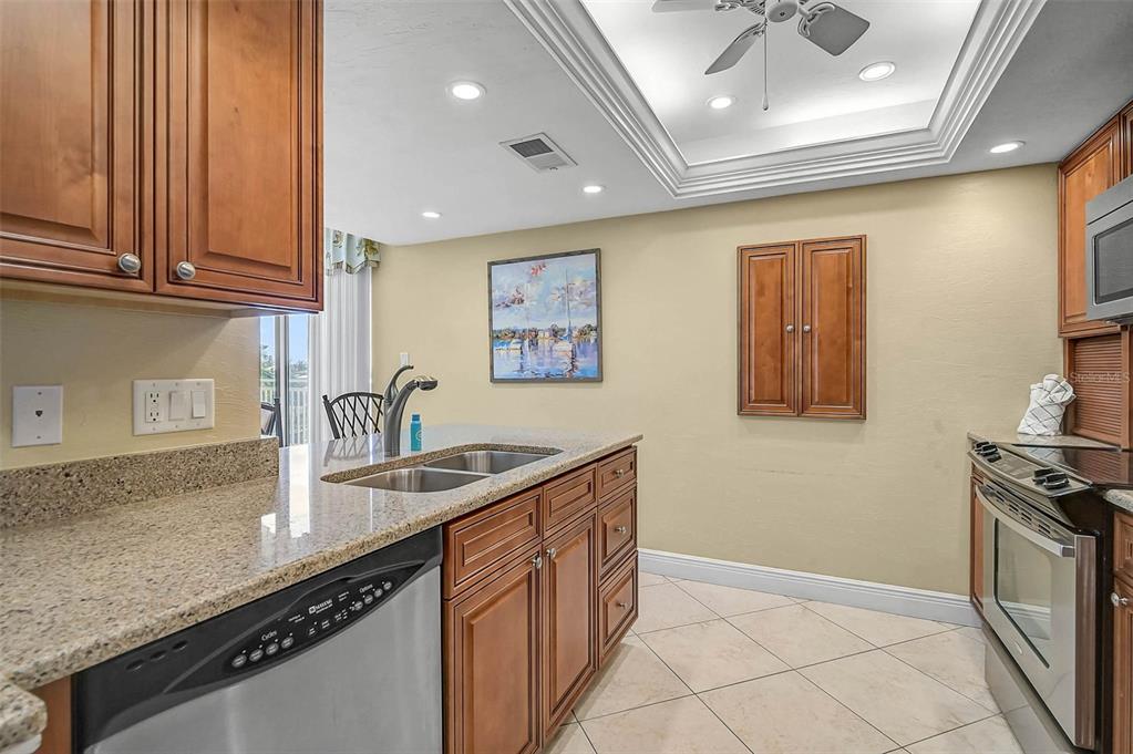 6518 Midnight Pass Road, Unit 407 Sarasota, FL 34242 - Photo 25 of 48 a kitchen with stainless steel appliances granite countertop a sink stove and cabinets