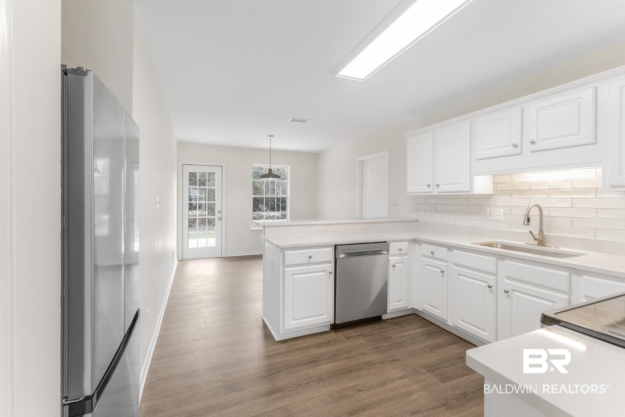 16330 Absalom Street Foley, AL 36535 - Photo 17 of 42 Kitchen featuring white cabinetry, sink, kitchen peninsula, and appliances with stainless steel finishes