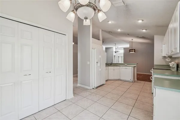 a kitchen that has a sink and a stove with white countertops