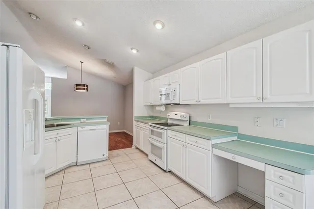 a view of a kitchen with wooden floor and a window