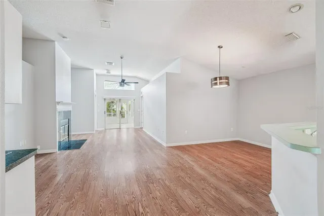 a view of a kitchen with wooden floor and a ceiling fan