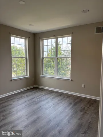 an empty room with wooden floor and a window