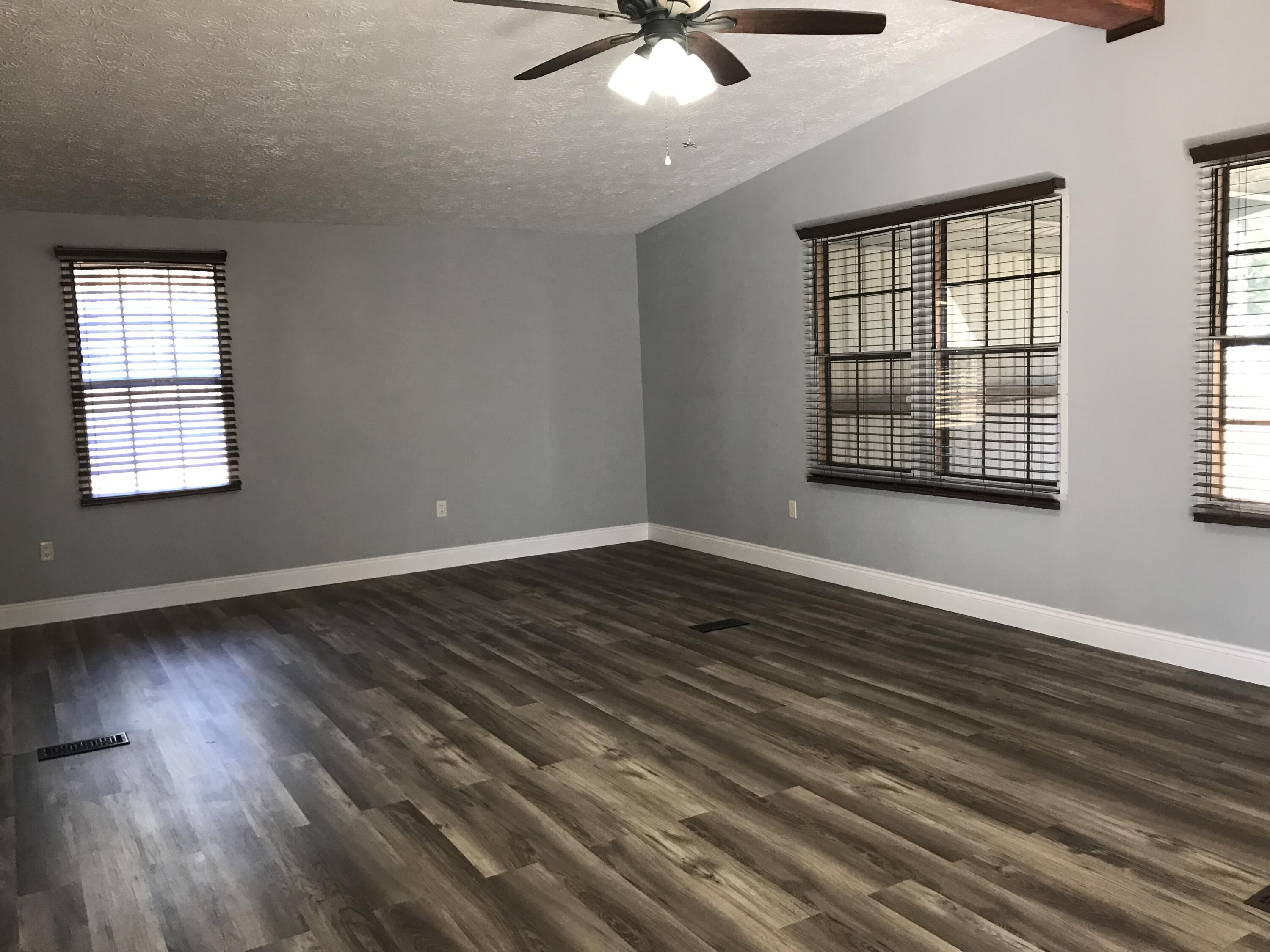 5806 Bush Road Baker, FL 32531 - Photo 3 of 17 a view of an empty room with wooden floor and a window