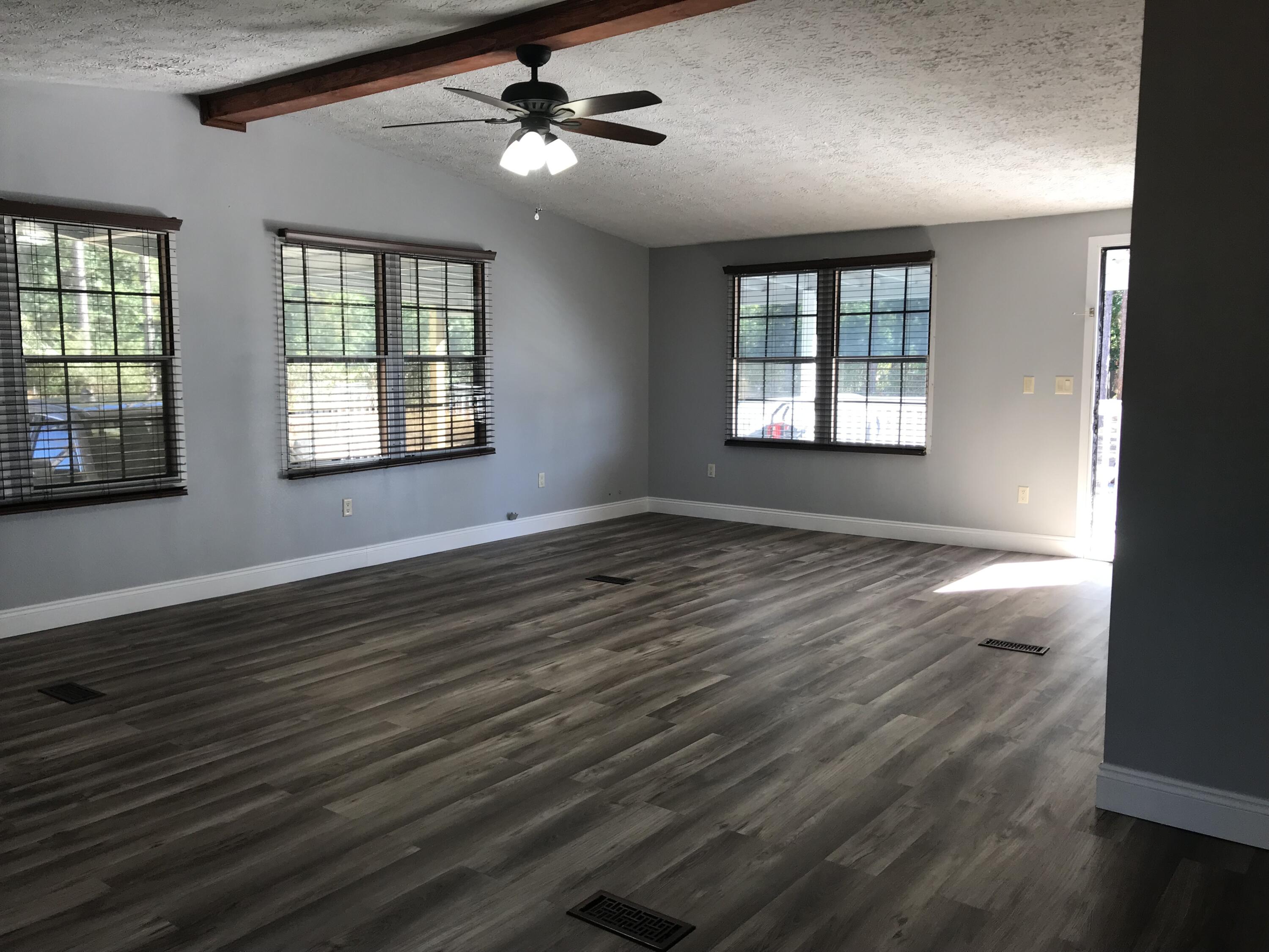 5806 Bush Road Baker, FL 32531 - Photo 6 of 17 a view of an empty room with wooden floor and a window