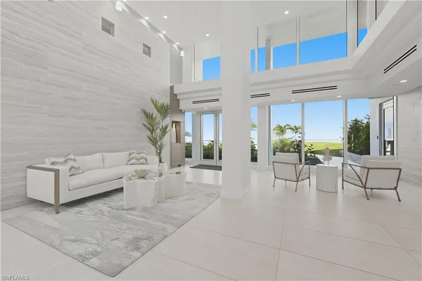 a living room with couches and kitchen view with wooden floor