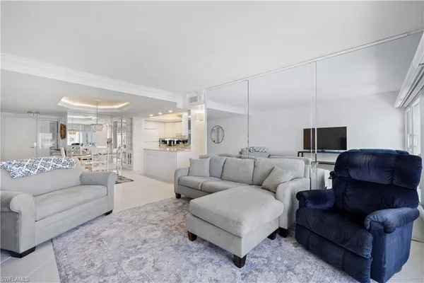 a living room with furniture and view of kitchen