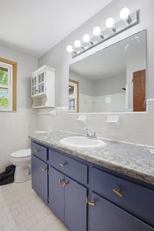 a bathroom with a granite countertop sink a toilet and a mirror