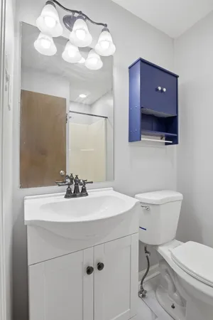a bathroom with a toilet a sink and mirror