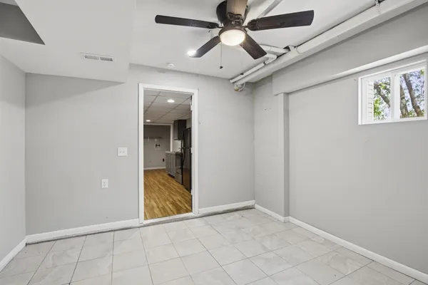 an empty room with windows and fan
