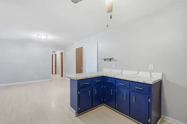 a kitchen with stainless steel appliances granite countertop a sink and cabinets with wooden floor