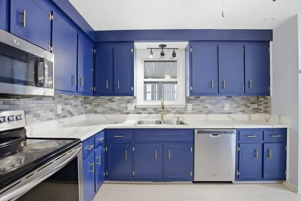 a kitchen with stainless steel appliances granite countertop wooden cabinets and a stove top oven