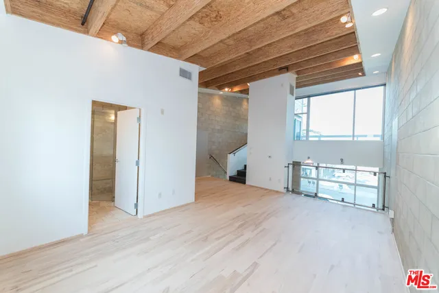 a view of empty room with window and wooden floor