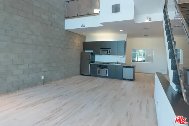 a large kitchen with cabinets wooden floor and stainless steel appliances