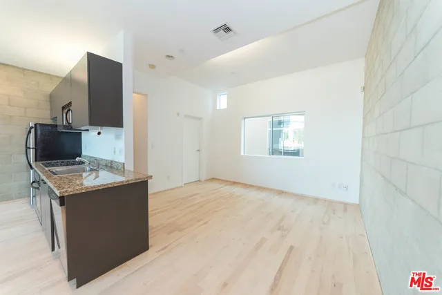 an empty room with a kitchen and a stove top oven
