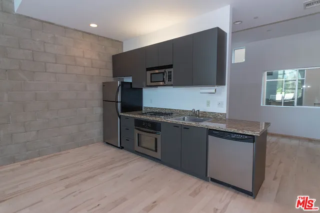 a kitchen with granite countertop a stove and a wooden floor