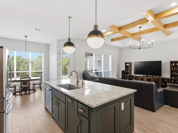 a kitchen with stainless steel appliances granite countertop a sink refrigerator and cabinets