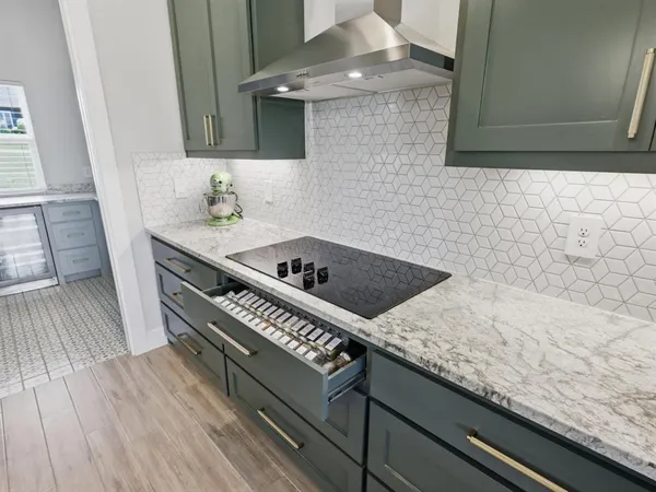 a kitchen with a sink a island a stove cabinets and wooden floor