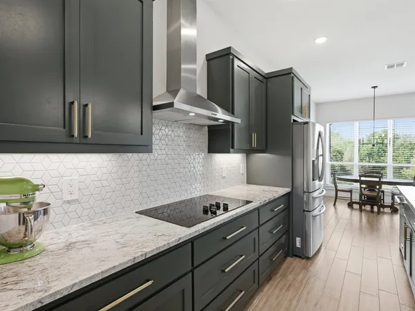 a kitchen with stainless steel appliances granite countertop a refrigerator and a sink