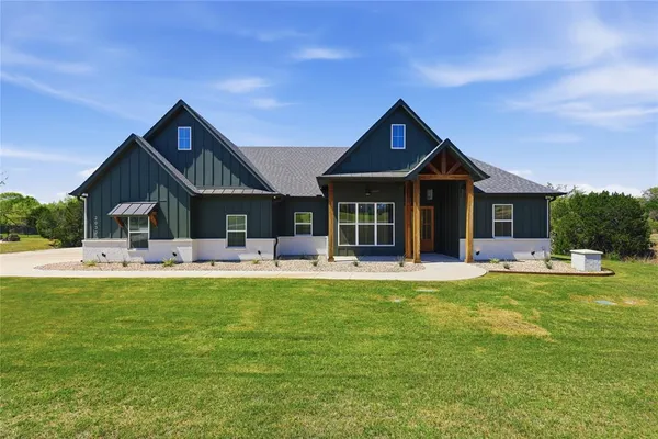 a front view of house with yard barbeque and outdoor seating