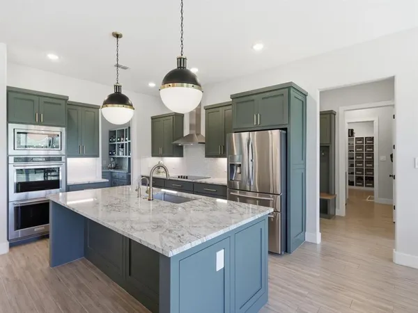 a kitchen with a refrigerator a sink and a dining table
