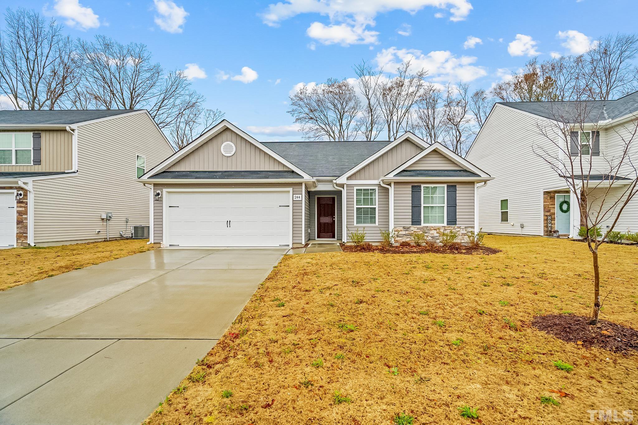 244 Rustling Way Zebulon, NC 27597 - Photo 25 of 25 a front view of a house with a yard and garage