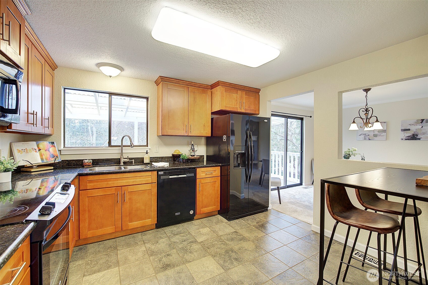 26229 197th Place Southeast Covington, WA 98042 - Photo 11 of 39 a kitchen with stainless steel appliances granite countertop a refrigerator a stove a sink dishwasher a dining table and chairs with wooden floor