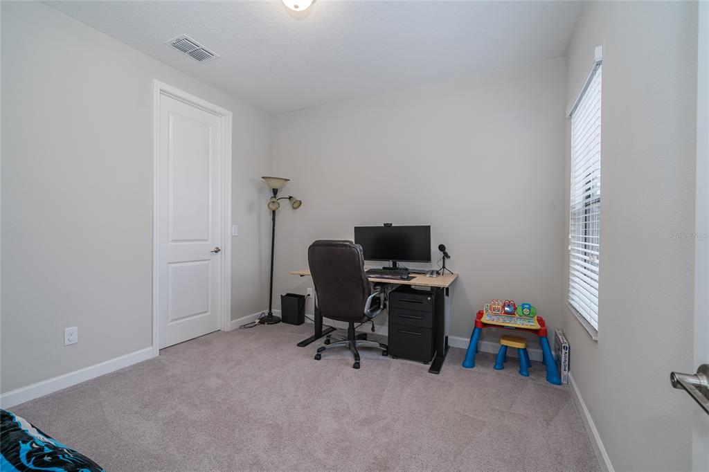 8099 Lago Mist Way Wesley Chapel, FL 33545 - Photo 36 of 56 a view of a workspace with furniture and a window