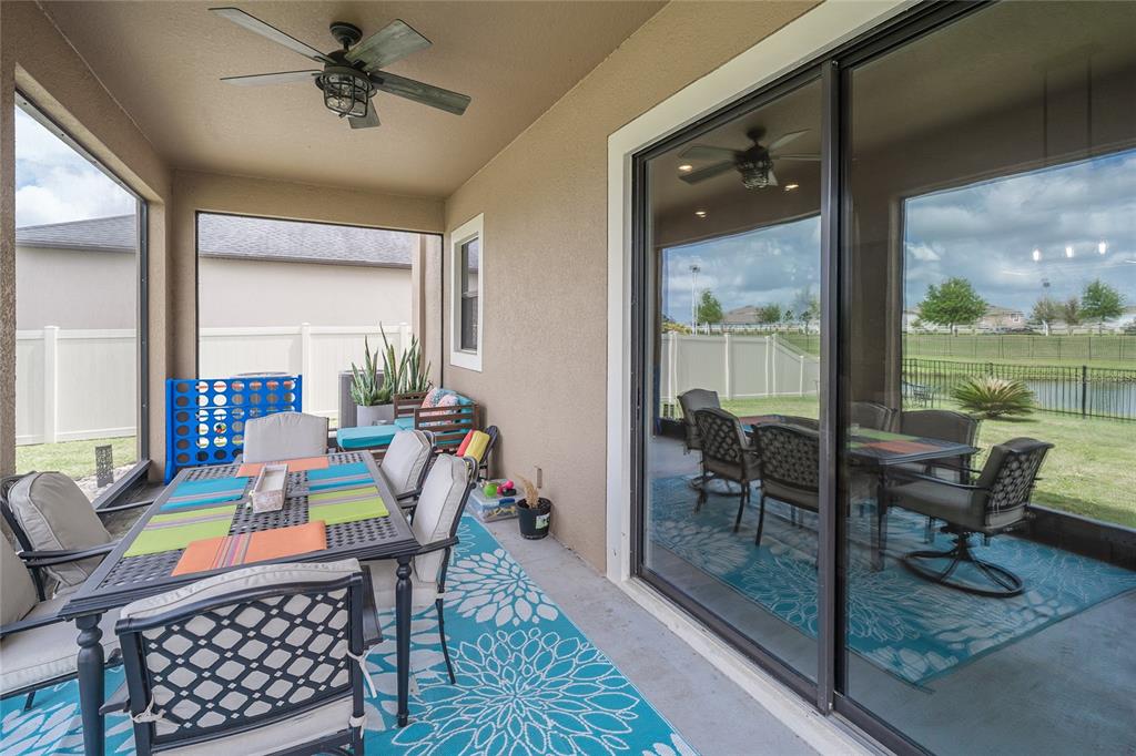 8099 Lago Mist Way Wesley Chapel, FL 33545 - Photo 39 of 56 a dining room with furniture a rug and a floor to ceiling window