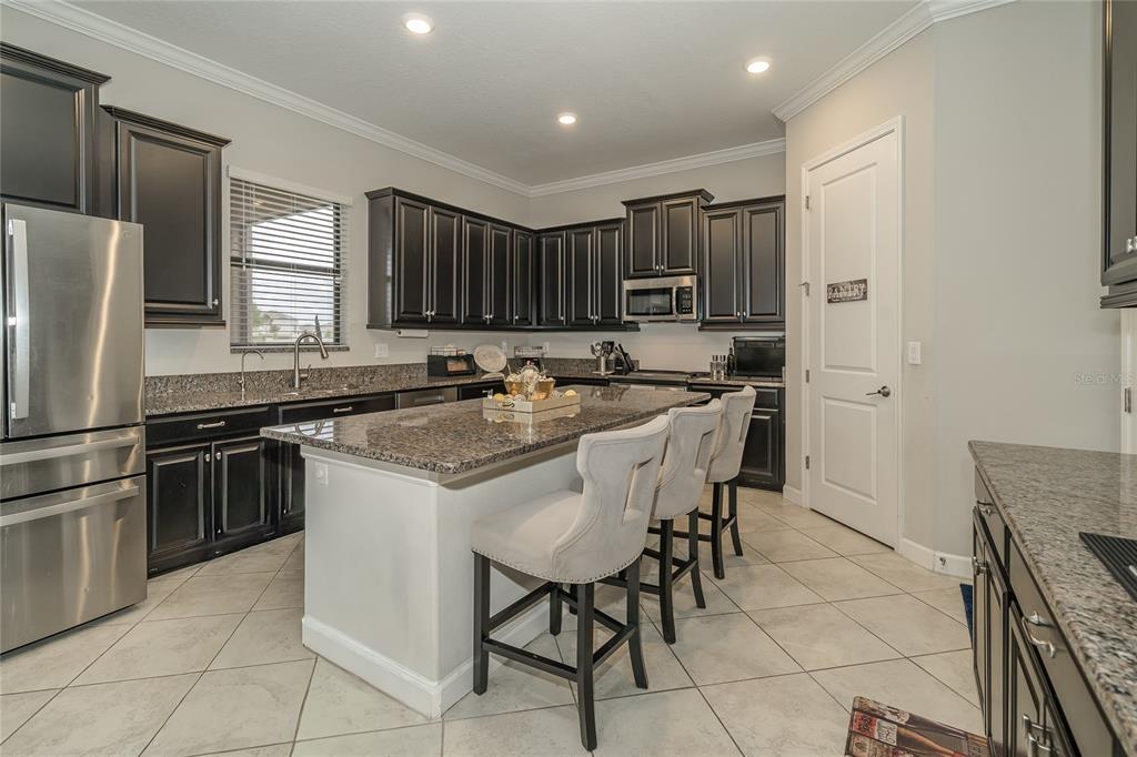 8099 Lago Mist Way Wesley Chapel, FL 33545 - Photo 4 of 56 a kitchen with stainless steel appliances granite countertop a stove a sink a microwave and a refrigerator