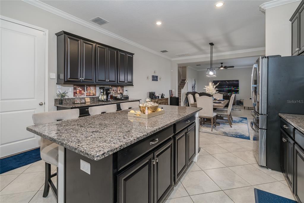 8099 Lago Mist Way Wesley Chapel, FL 33545 - Photo 8 of 56 a kitchen with granite countertop a sink and a refrigerator