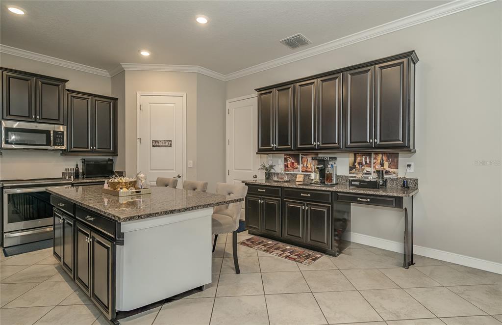 8099 Lago Mist Way Wesley Chapel, FL 33545 - Photo 9 of 56 a kitchen with stainless steel appliances granite countertop a stove top oven a sink dishwasher and a refrigerator