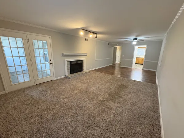 an empty room with windows and fireplace