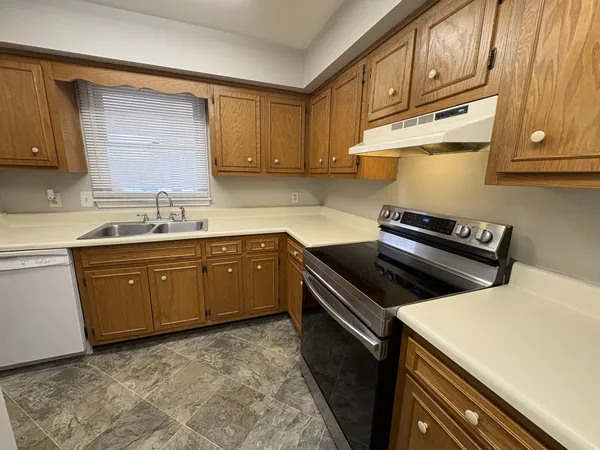 a kitchen with a sink stove top oven and cabinets
