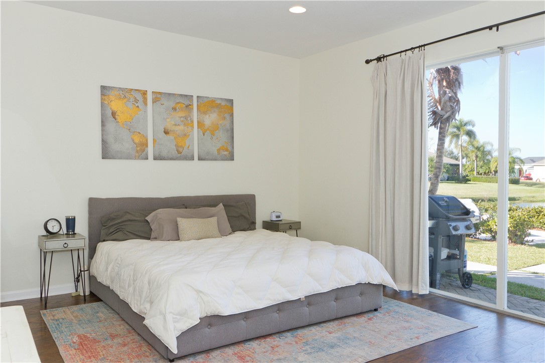 628 Tangelo Circle Southwest Vero Beach, FL 32968 - Photo 16 of 36 a bedroom with a bed and a large mirror next to a window