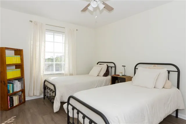 a bedroom with two beds and a flat tv screen on dresser