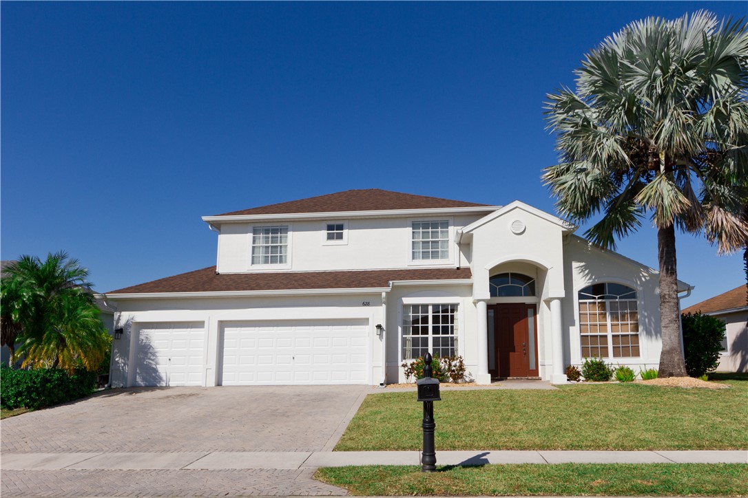 628 Tangelo Circle Southwest Vero Beach, FL 32968 - Photo 2 of 36 a front view of a house with a yard and garage