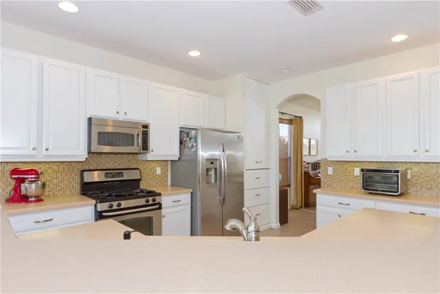 a kitchen with stainless steel appliances a refrigerator and a stove top oven