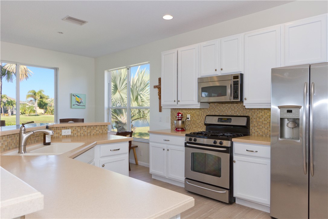 628 Tangelo Circle Southwest Vero Beach, FL 32968 - Photo 10 of 36 a kitchen with a sink stove and microwave