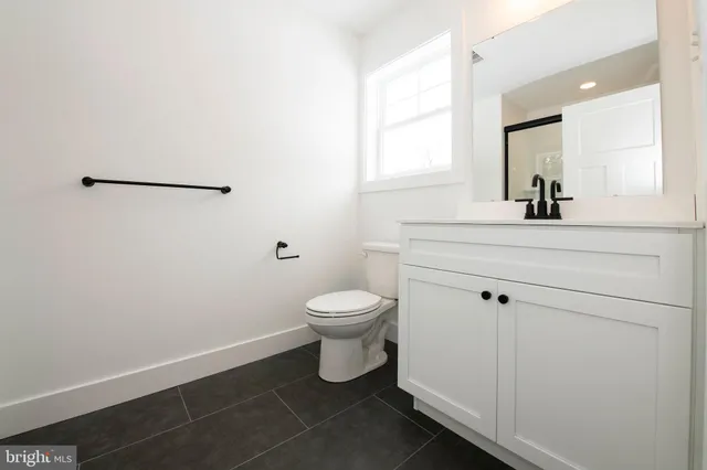a bathroom with a toilet a sink and mirror
