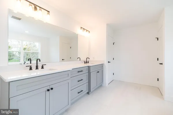 a bathroom with a double vanity sink and mirror