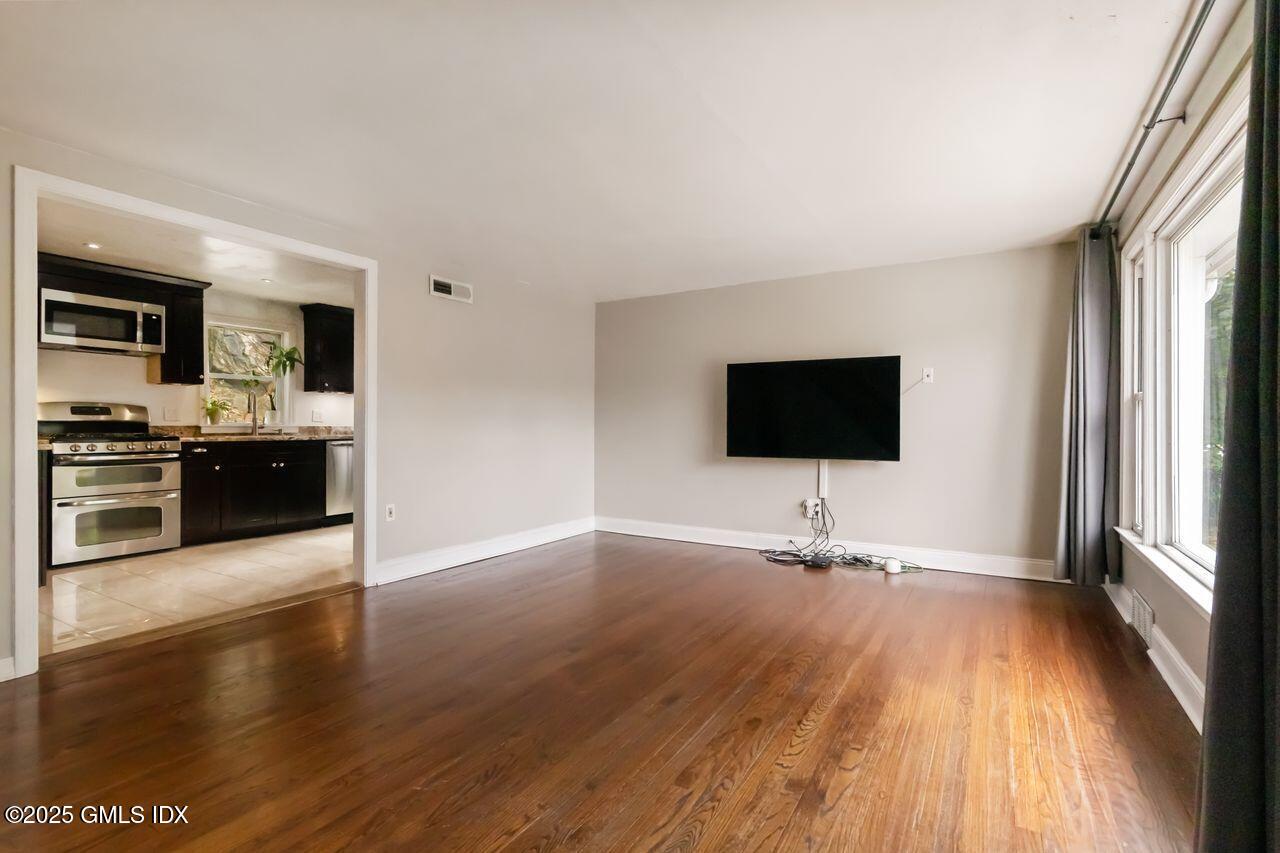 207 Sheep Hill Road Riverside, CT 06878 - Photo 5 of 18 a living room with stainless steel appliances wooden floor and large windows