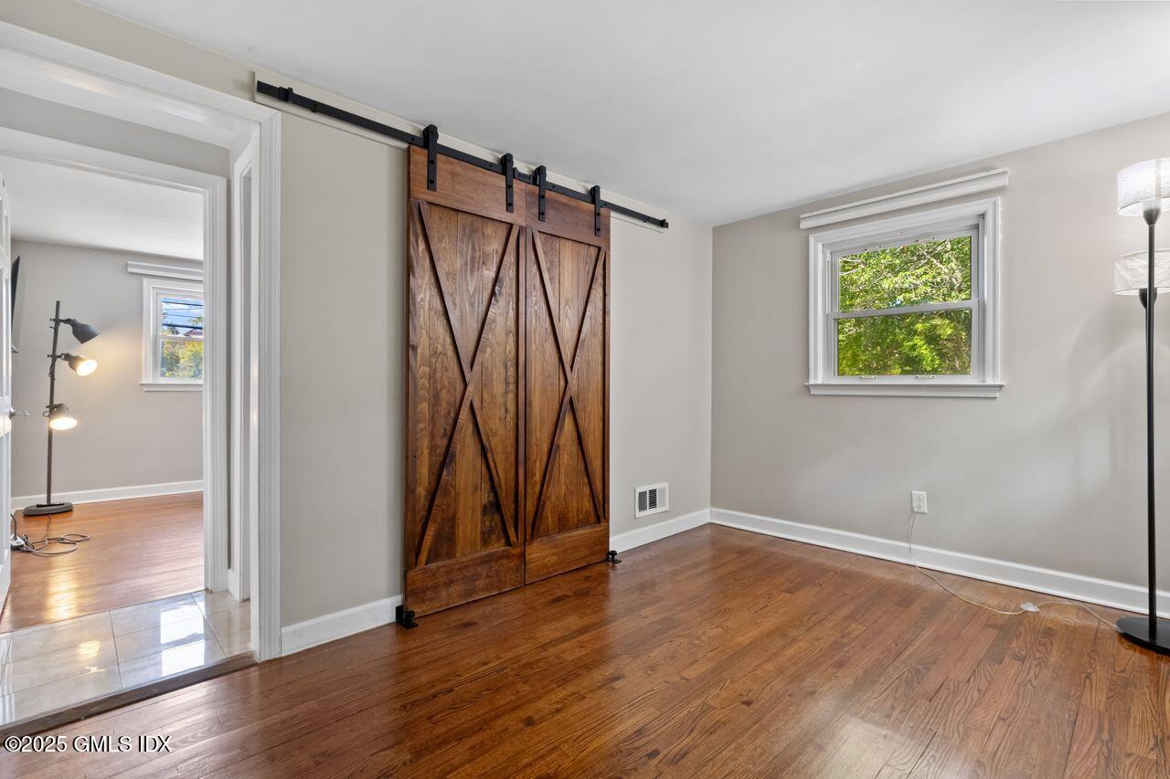 207 Sheep Hill Road Riverside, CT 06878 - Photo 8 of 18 an empty room with wooden floor and a window