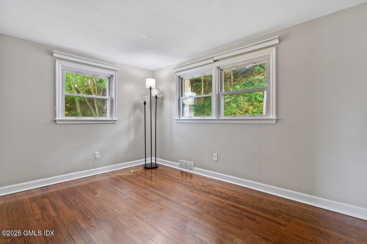 207 Sheep Hill Road Riverside, CT 06878 - Photo 9 of 18 an empty room with wooden floor and windows