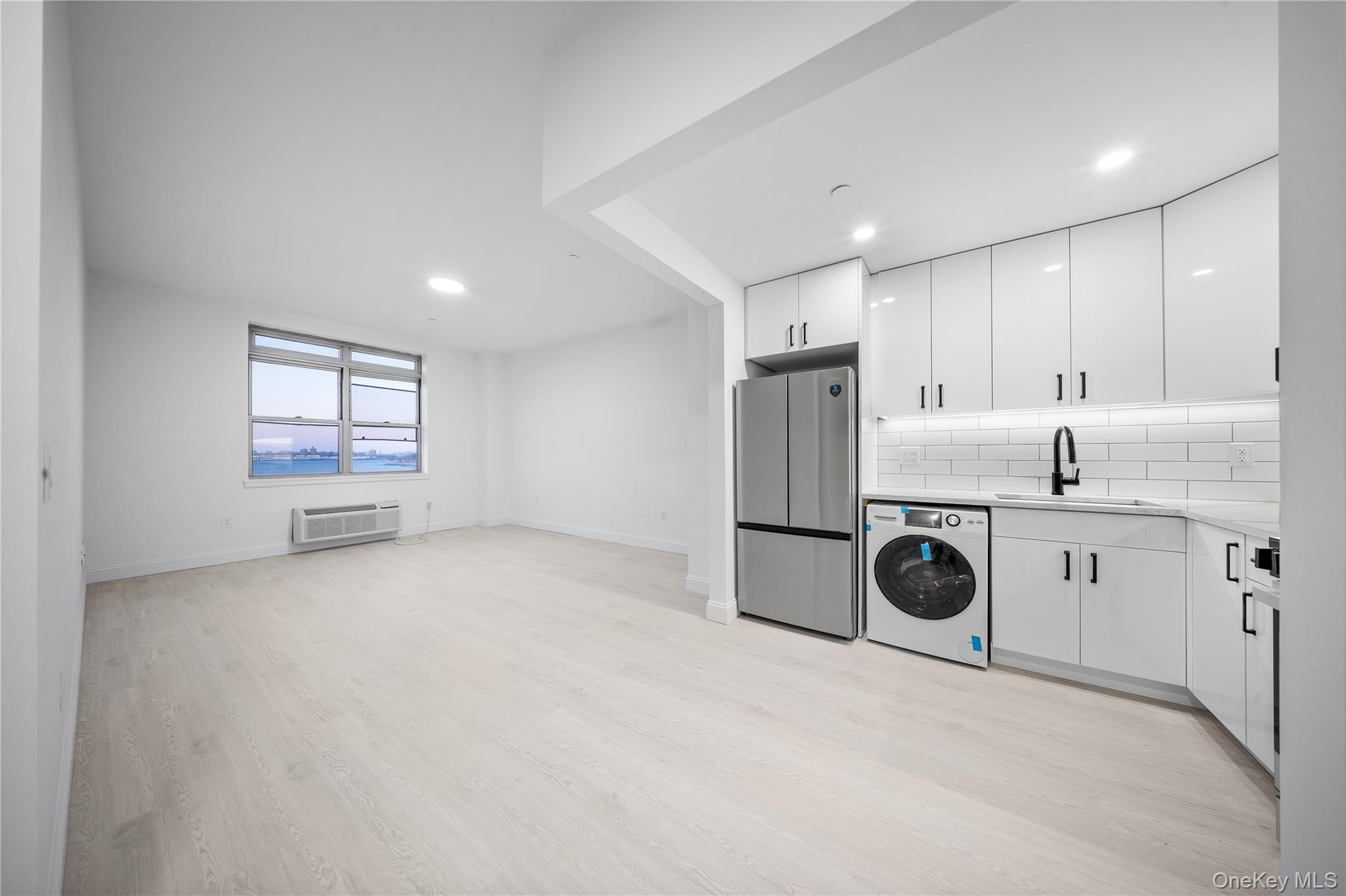 14-34 110th Street, Unit 5I Queens, NY 11356 - Photo 2 of 17 a kitchen with a refrigerator and white cabinets