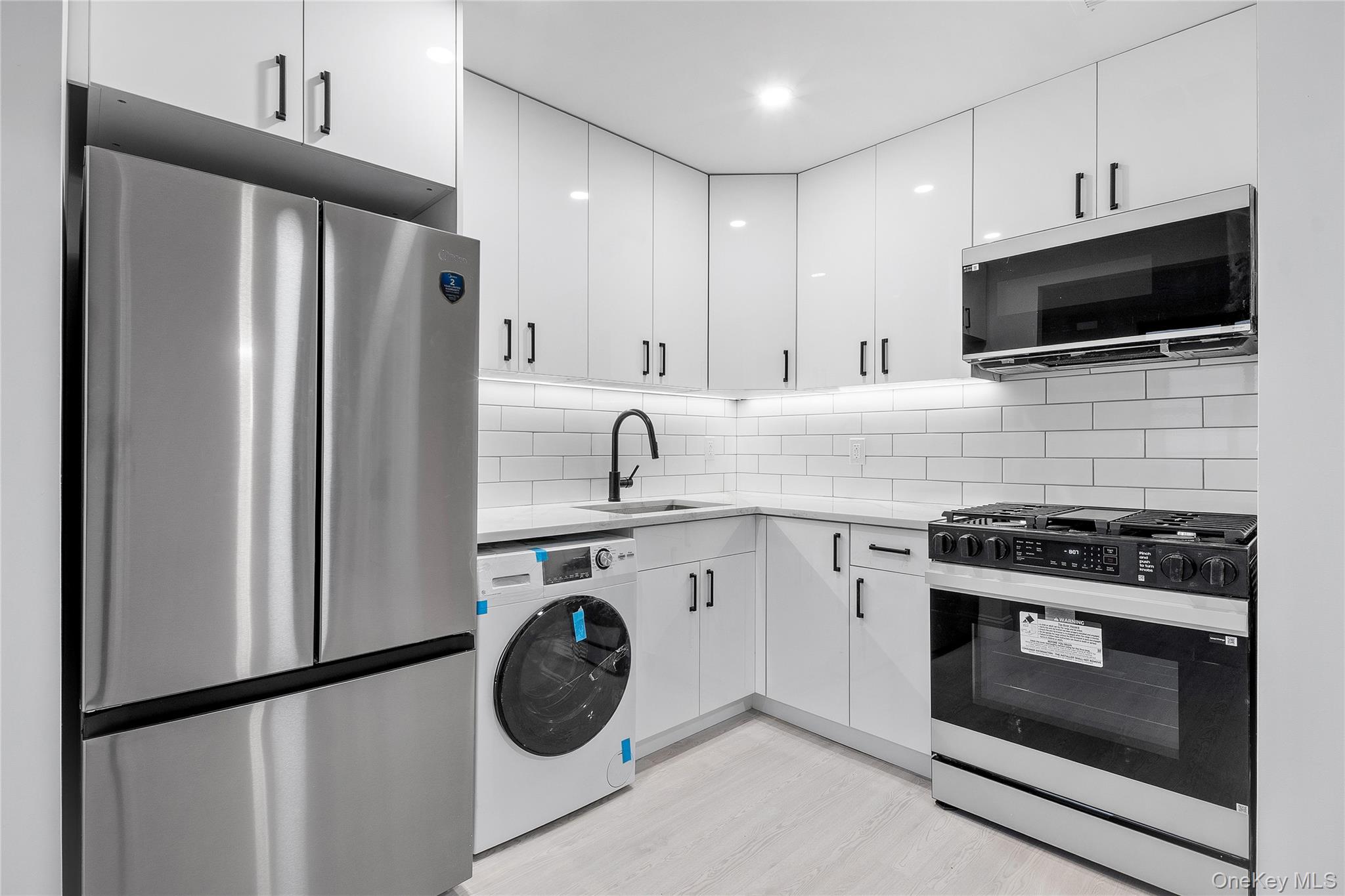14-34 110th Street, Unit 5I Queens, NY 11356 - Photo 7 of 17 a kitchen with stainless steel appliances a stove microwave and refrigerator