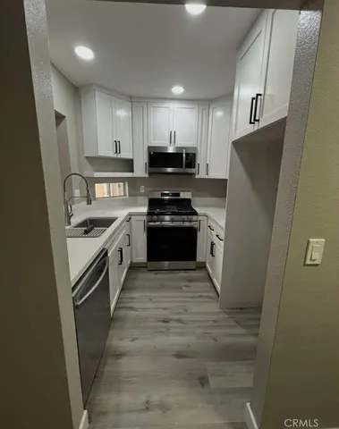 a kitchen with granite countertop a refrigerator stove and sink
